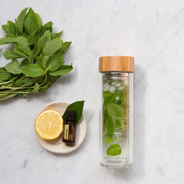 Glass fressko flask with mint leaves lemon and Doterra lemon oil