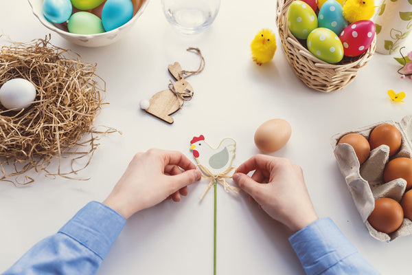 person creating easter decorations surrounded by craft equipment